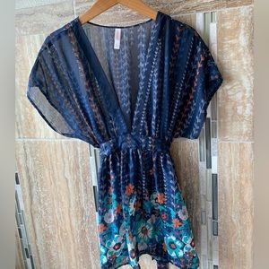 Navy tunic with rust and teal colored flowers. Tie in the back